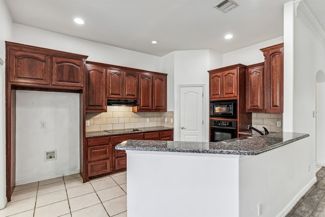 kitchen featuring kitchen peninsula, black appliances, sink, backsplash, and dark stone countertops