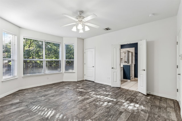 unfurnished bedroom with hardwood / wood-style floors, ensuite bathroom, and ceiling fan