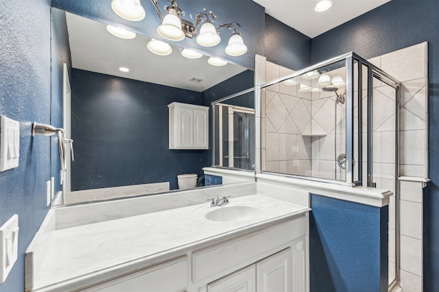 bathroom featuring vanity, toilet, and a shower with door