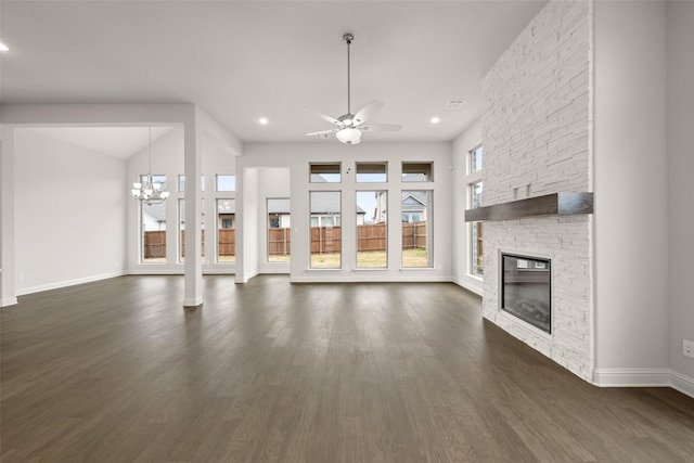 unfurnished living room with recessed lighting, ceiling fan with notable chandelier, a fireplace, baseboards, and dark wood-style floors