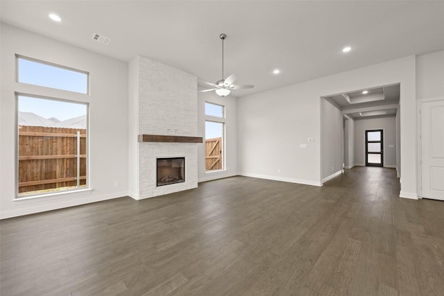 unfurnished living room with ceiling fan, recessed lighting, dark wood-style flooring, a fireplace, and baseboards