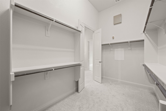 walk in closet featuring light colored carpet