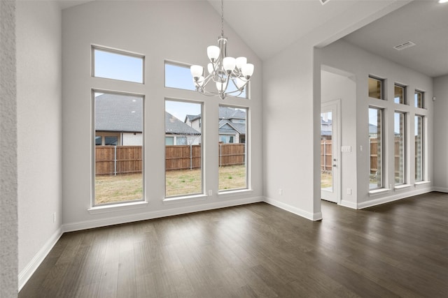 unfurnished dining area with baseboards, visible vents, dark wood finished floors, a chandelier, and high vaulted ceiling