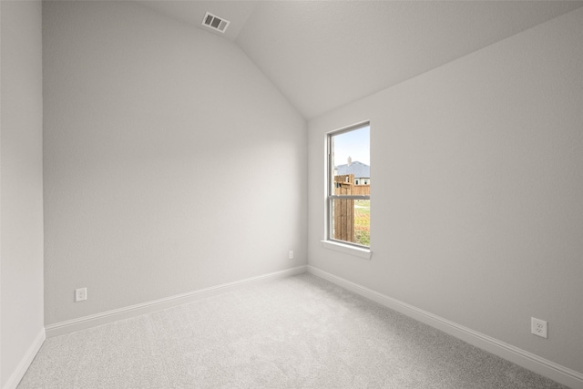 unfurnished room with lofted ceiling, carpet, visible vents, and baseboards