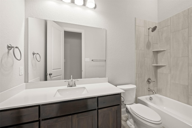 bathroom with shower / washtub combination, a textured wall, vanity, and toilet