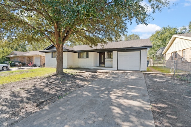 ranch-style home featuring an attached garage, fence, and concrete driveway