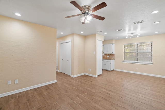 unfurnished living room featuring ceiling fan and light hardwood / wood-style flooring