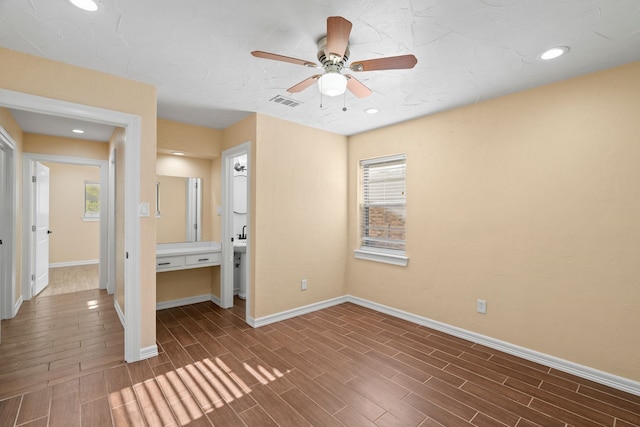 unfurnished bedroom featuring dark wood-type flooring, ceiling fan, and multiple windows