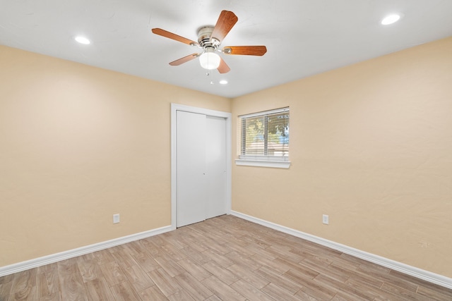 unfurnished bedroom with a closet, light hardwood / wood-style floors, and ceiling fan