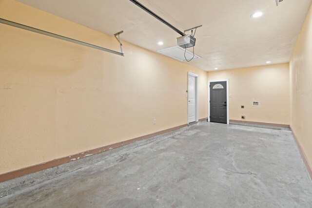 garage featuring recessed lighting, baseboards, and a garage door opener