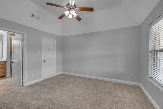 unfurnished bedroom with light carpet, ceiling fan, vaulted ceiling, and a closet