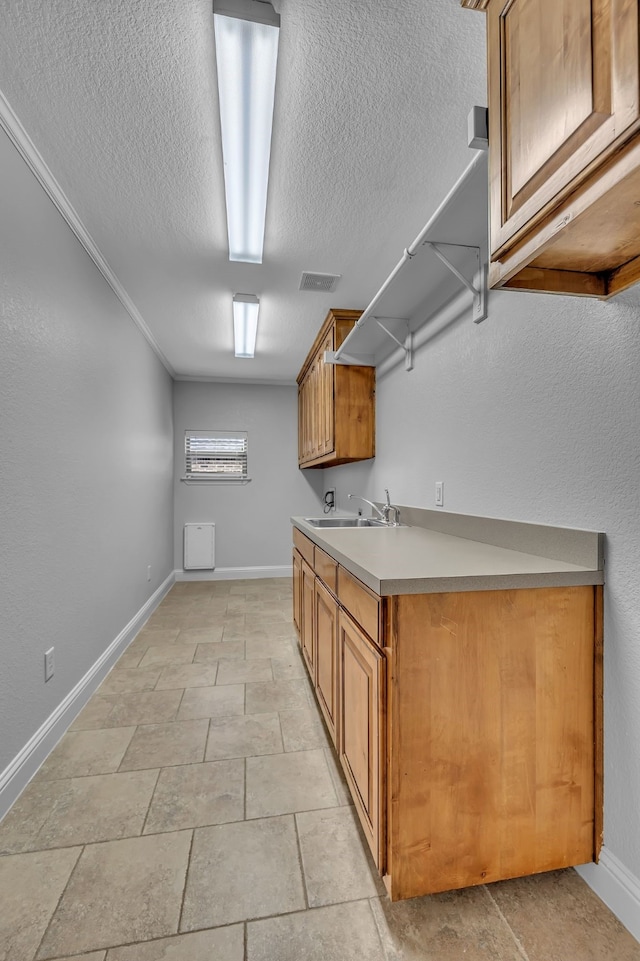 kitchen featuring a textured ceiling and sink