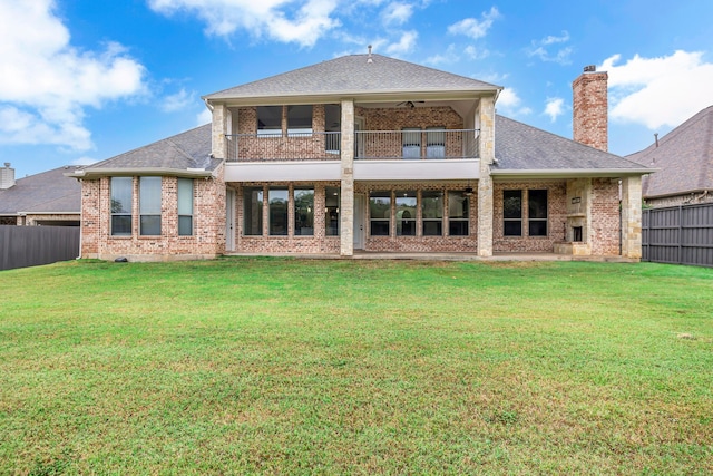 back of property with a lawn, ceiling fan, and a balcony