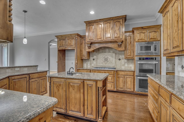 kitchen with stainless steel appliances, hardwood / wood-style flooring, hanging light fixtures, and a center island