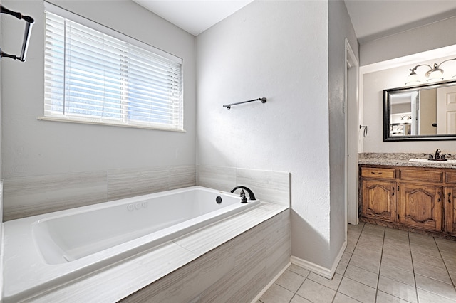 bathroom featuring tile patterned flooring, vanity, and tiled tub