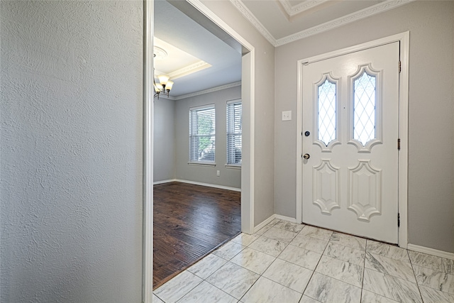 foyer with an inviting chandelier and crown molding