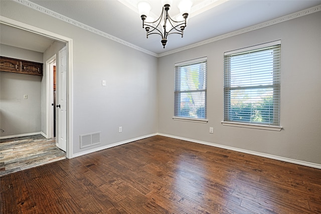 unfurnished room with hardwood / wood-style flooring, an inviting chandelier, and crown molding