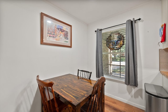 dining area with hardwood / wood-style floors and crown molding