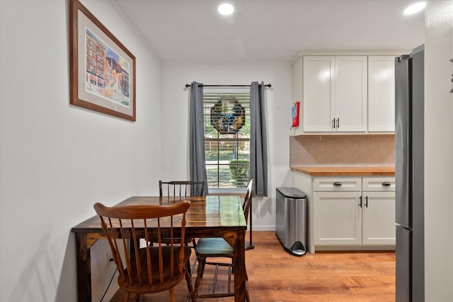 dining area with light hardwood / wood-style floors and crown molding