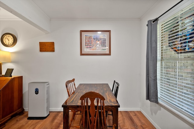 dining area with wood-type flooring and ornamental molding