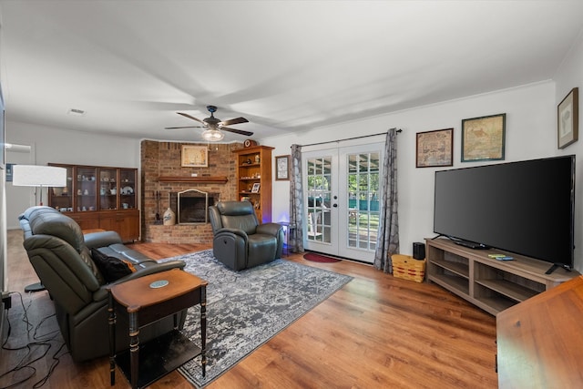 living room with a fireplace, hardwood / wood-style floors, french doors, and ceiling fan