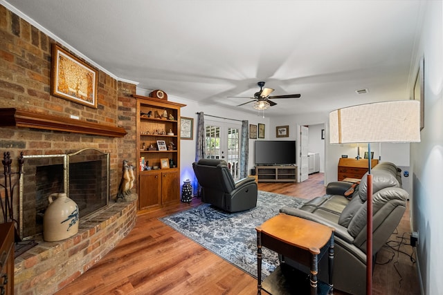 living room with a fireplace, ceiling fan, hardwood / wood-style floors, and french doors