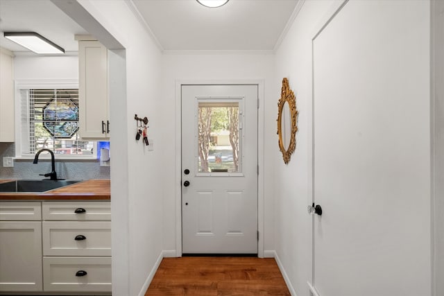 entryway featuring crown molding, sink, and wood-type flooring