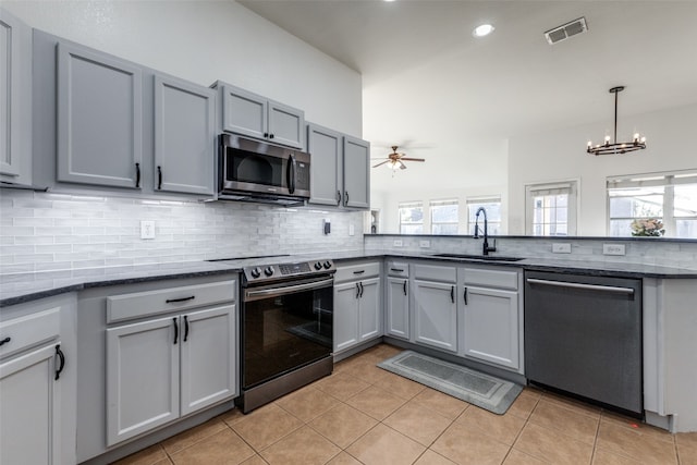 kitchen featuring ceiling fan with notable chandelier, a wealth of natural light, sink, and appliances with stainless steel finishes