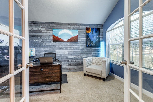 living area featuring carpet, wood walls, lofted ceiling, and french doors