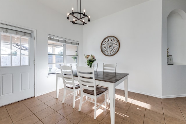 tiled dining space featuring vaulted ceiling and a chandelier