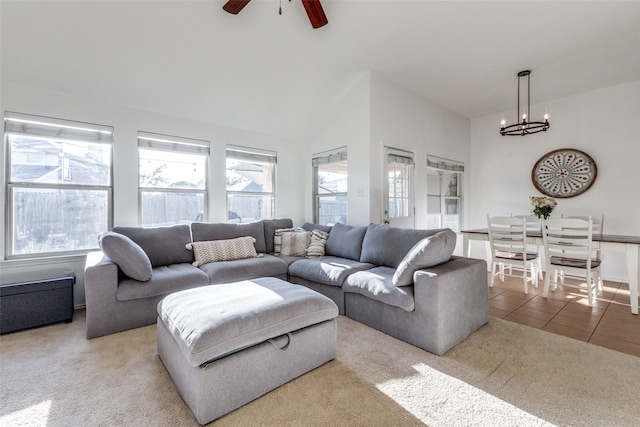 living room featuring carpet, ceiling fan with notable chandelier, and vaulted ceiling