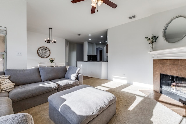 living room with light carpet, a fireplace, and ceiling fan