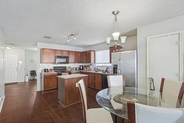 kitchen with pendant lighting, black appliances, a textured ceiling, a kitchen island, and dark hardwood / wood-style flooring