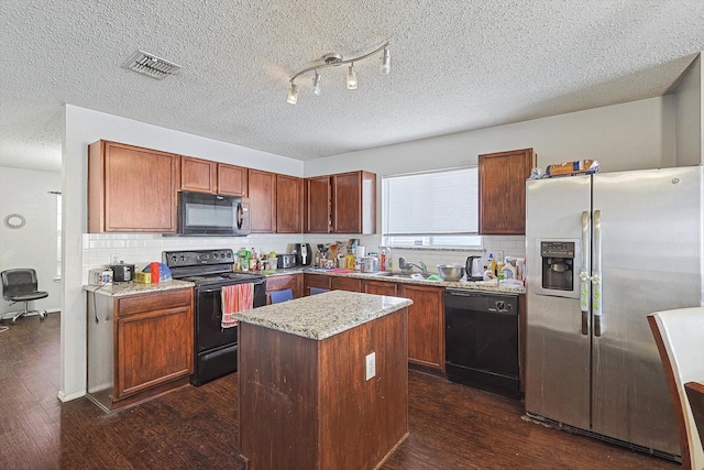 kitchen featuring a textured ceiling, a center island, dark hardwood / wood-style floors, and black appliances