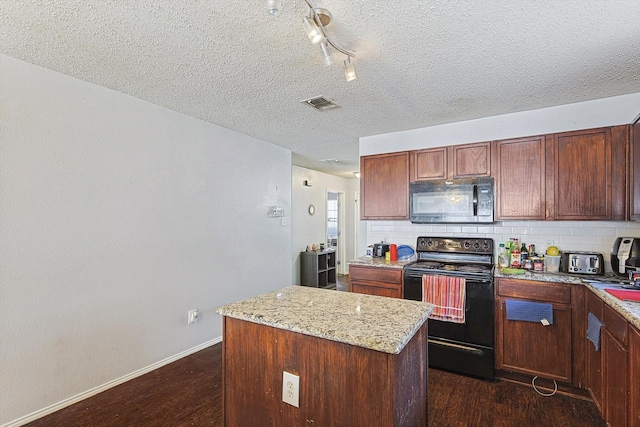 kitchen with light stone countertops, dark hardwood / wood-style flooring, backsplash, black appliances, and a center island