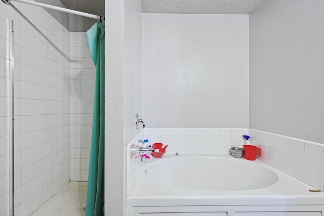 bathroom with shower with separate bathtub and a textured ceiling