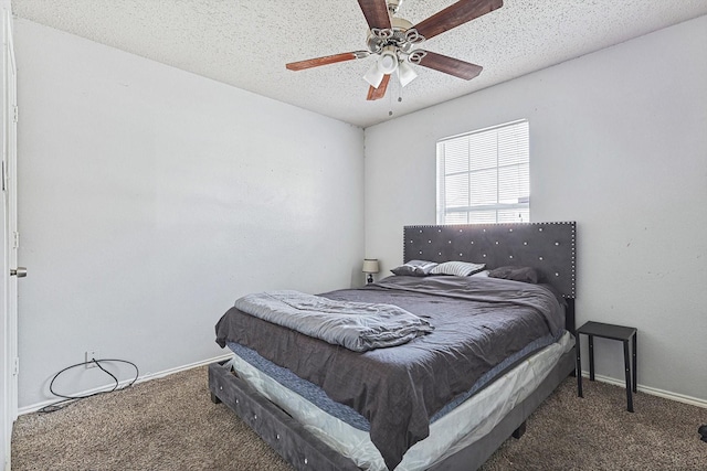 bedroom featuring ceiling fan, a textured ceiling, and dark colored carpet