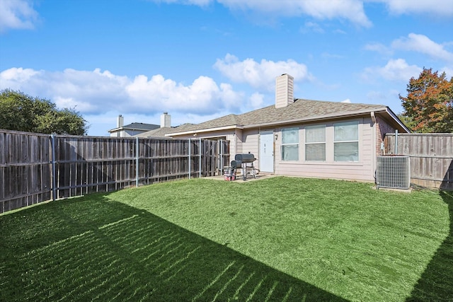 rear view of house with a yard and central AC unit