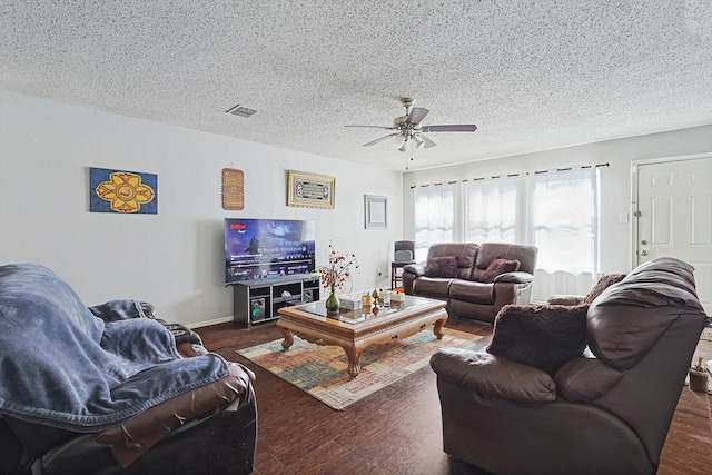 living room featuring a textured ceiling, dark hardwood / wood-style floors, and ceiling fan