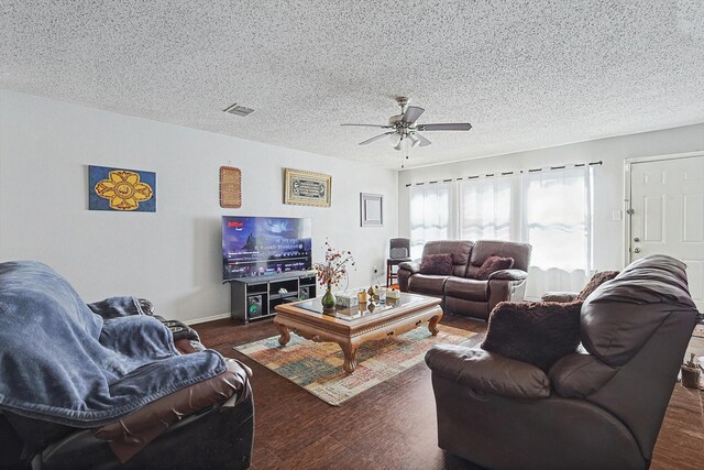 living room featuring a textured ceiling, dark hardwood / wood-style floors, and ceiling fan