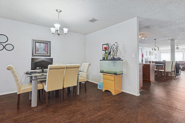 dining area featuring ceiling fan with notable chandelier, a textured ceiling, and dark hardwood / wood-style flooring