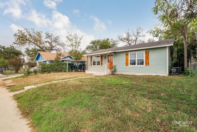 ranch-style home with cooling unit and a front lawn