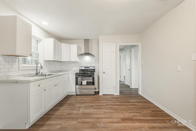 kitchen featuring white cabinets, wall chimney exhaust hood, sink, and stainless steel range