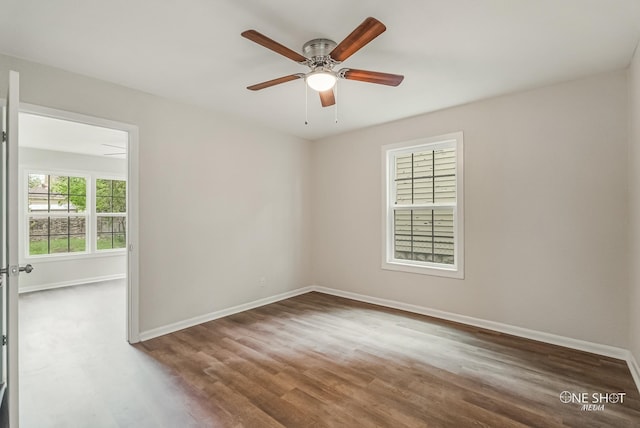 empty room with dark hardwood / wood-style floors and ceiling fan