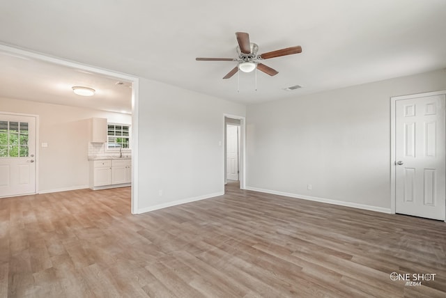 spare room with plenty of natural light, light wood-type flooring, and sink