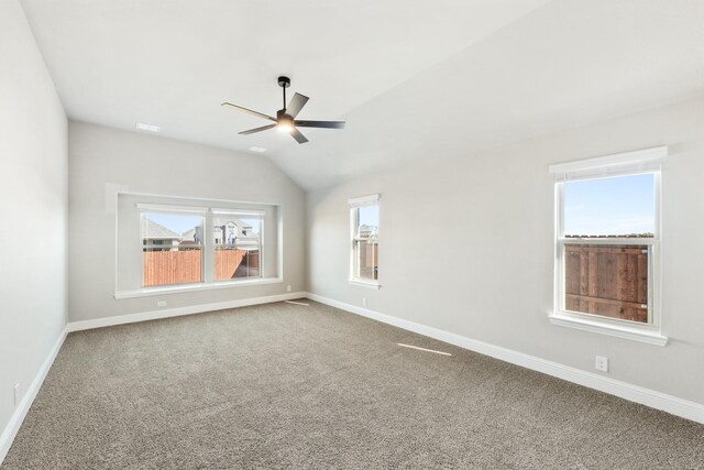 carpeted empty room featuring vaulted ceiling and ceiling fan