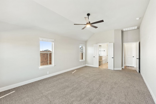 unfurnished bedroom featuring light carpet, ensuite bathroom, ceiling fan, and lofted ceiling