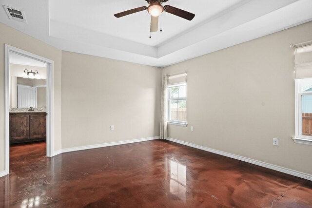 empty room featuring ceiling fan, a raised ceiling, and sink