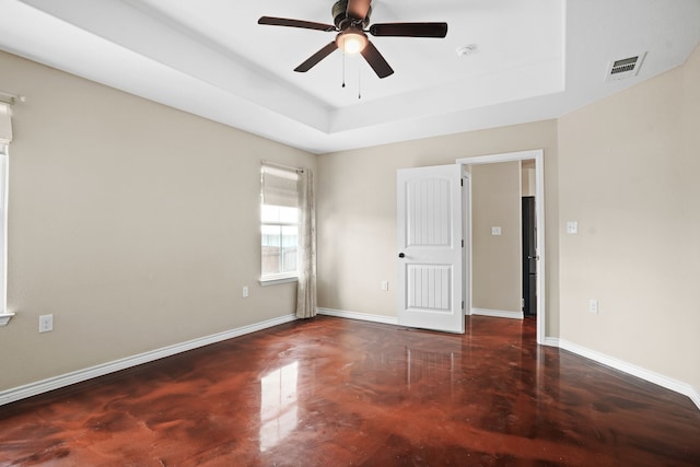 unfurnished room featuring ceiling fan and a raised ceiling