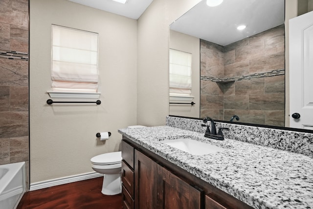 full bathroom with wood-type flooring, toilet, vanity, and tiled shower / bath